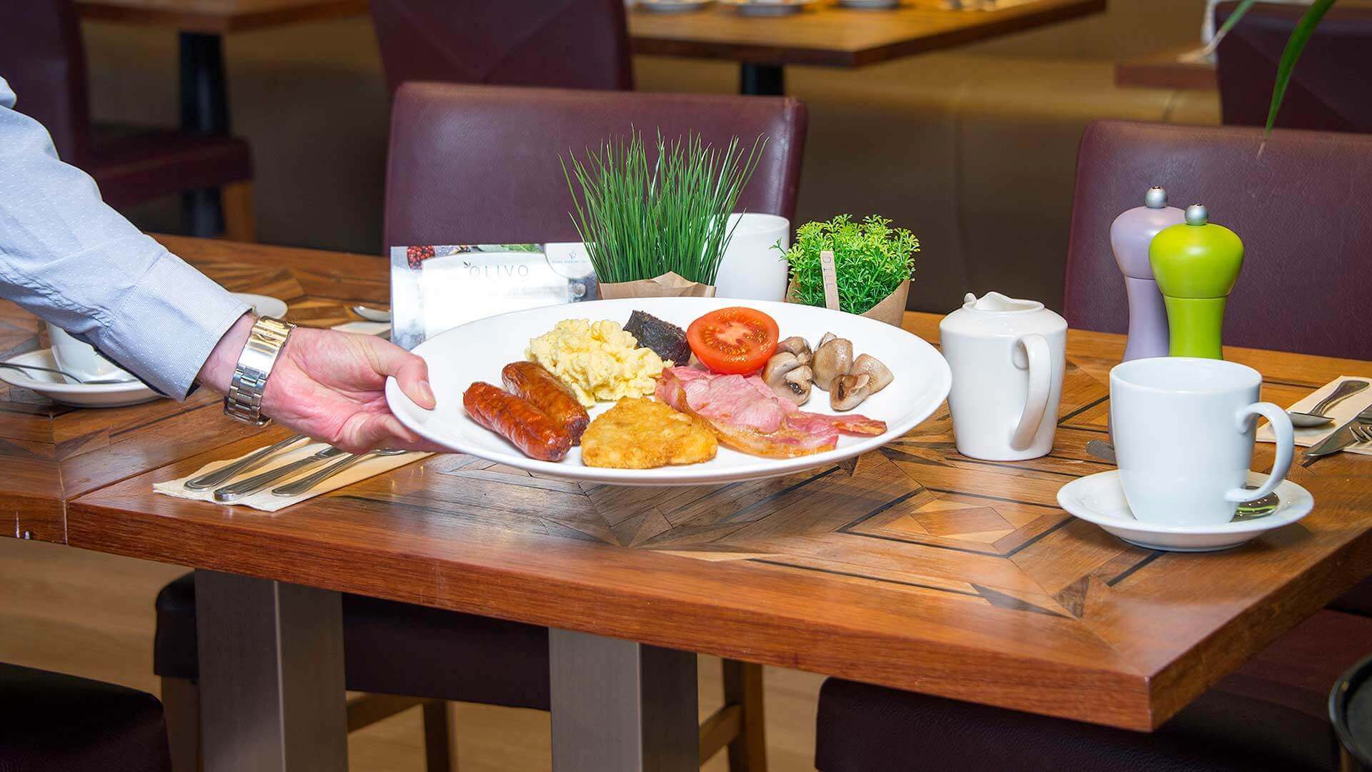 Waiter serving a full Irish breakfast at a table in the Cork Airport Hotel