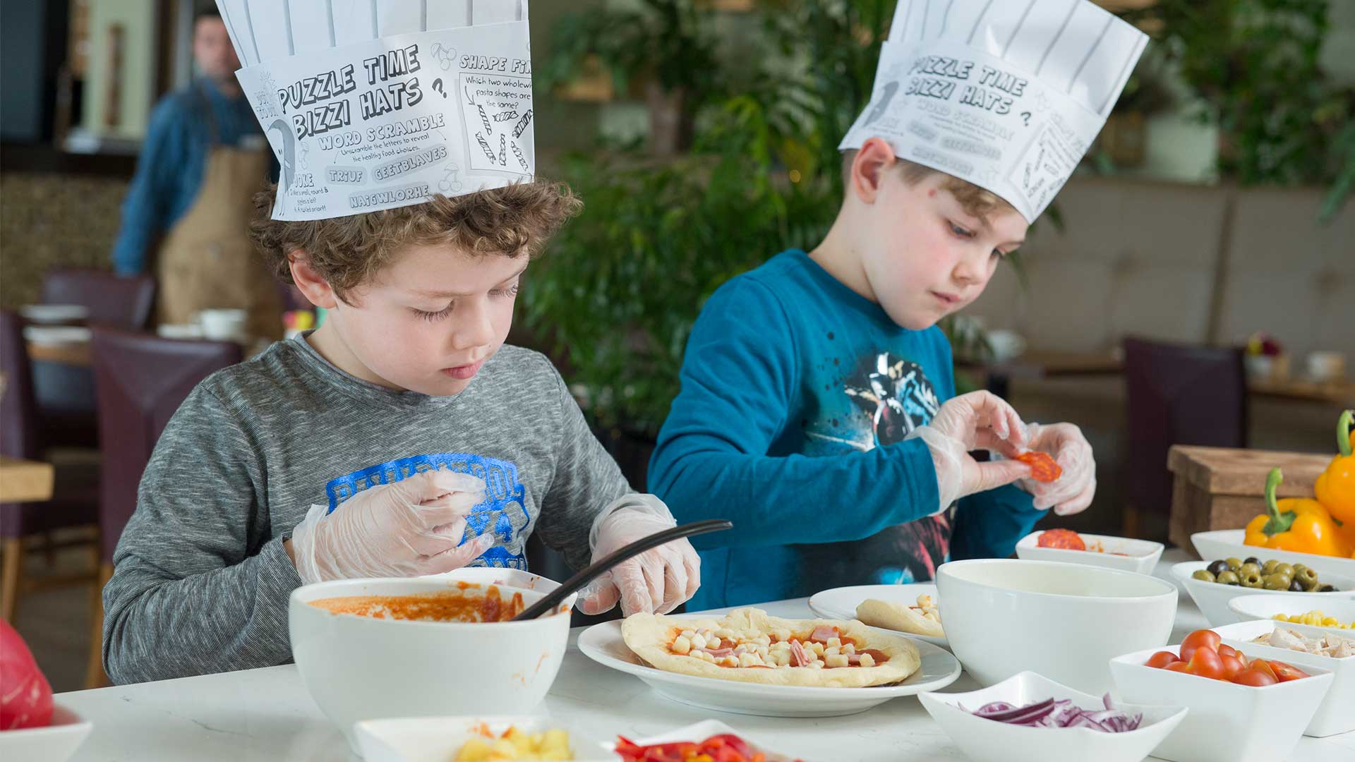 Two children taking part in a fun activity making their own pizzas at Cork Airport Hotel