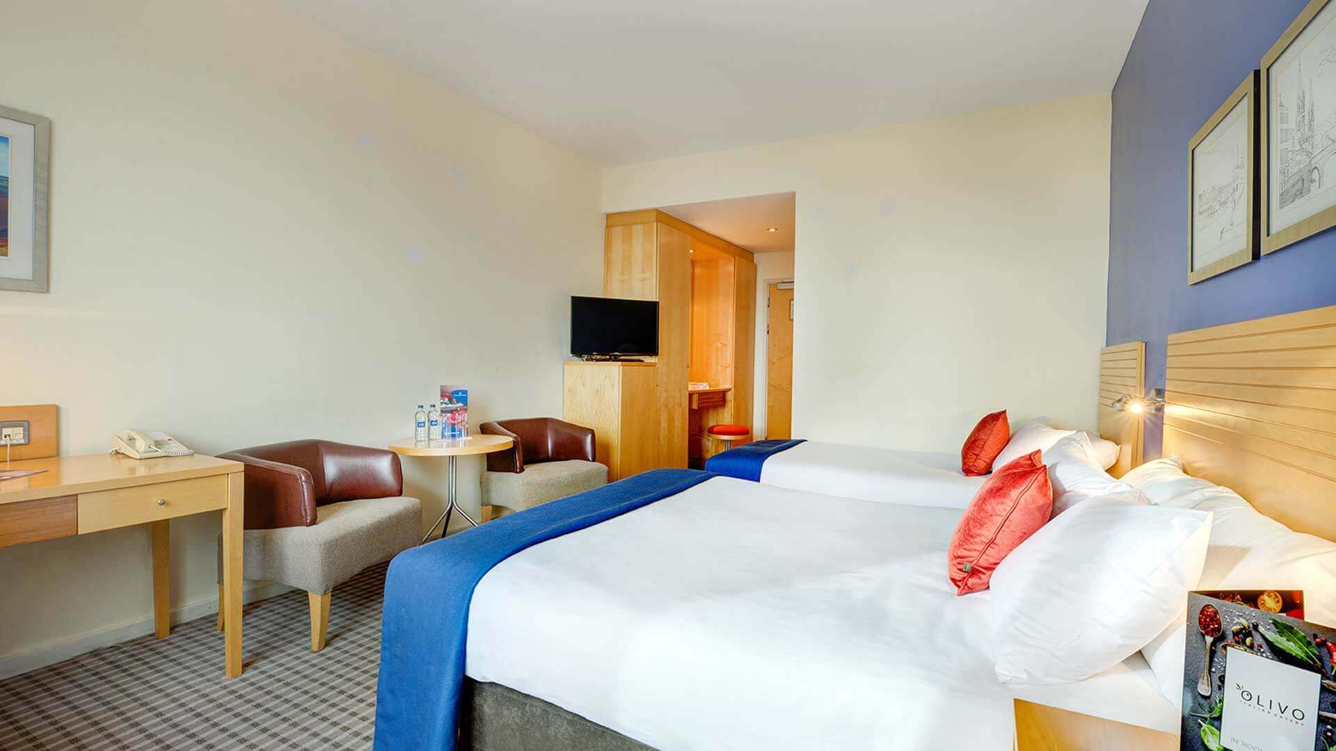 Two spotless beds and lounge area in Cork Airport Hotel Family Room