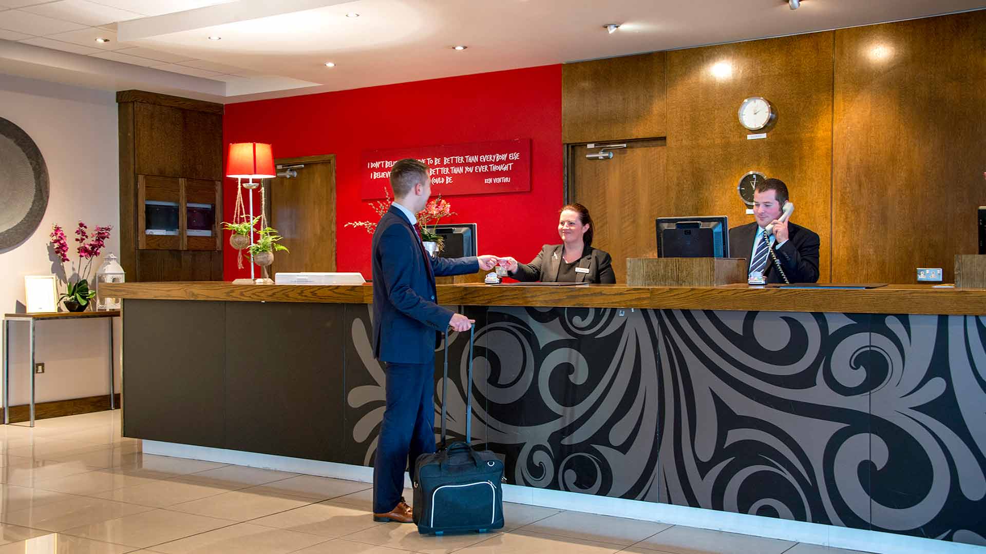 Receptionist handing guest his room key as he checks into the Cork Airport Hotel