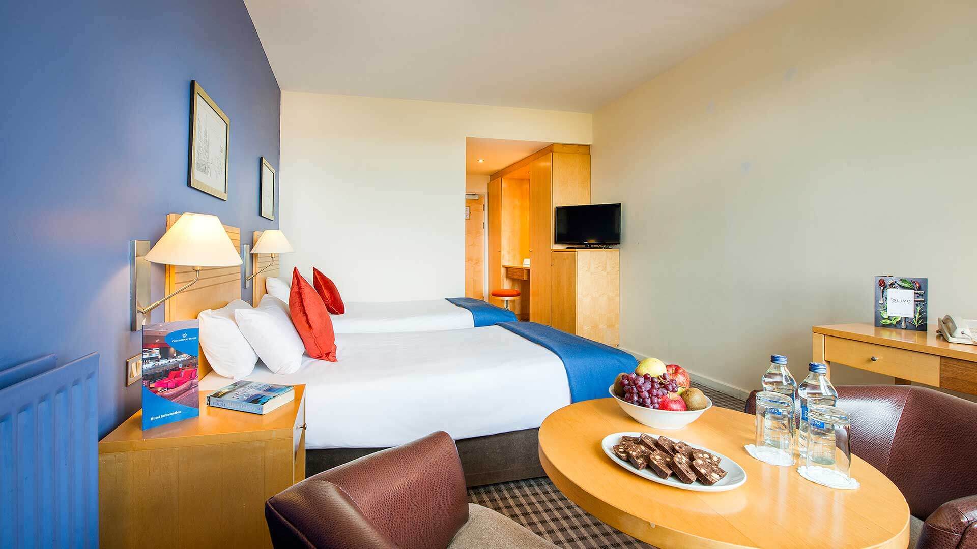 Twin room showing treats on the table and two spotless single beds