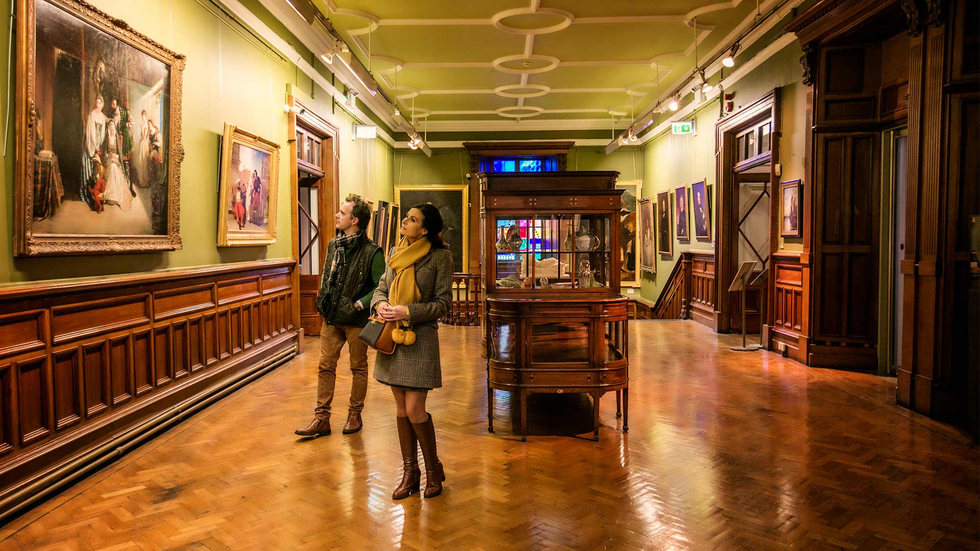 Two people browse the historical art collection at Crawford Art Gallery Cork