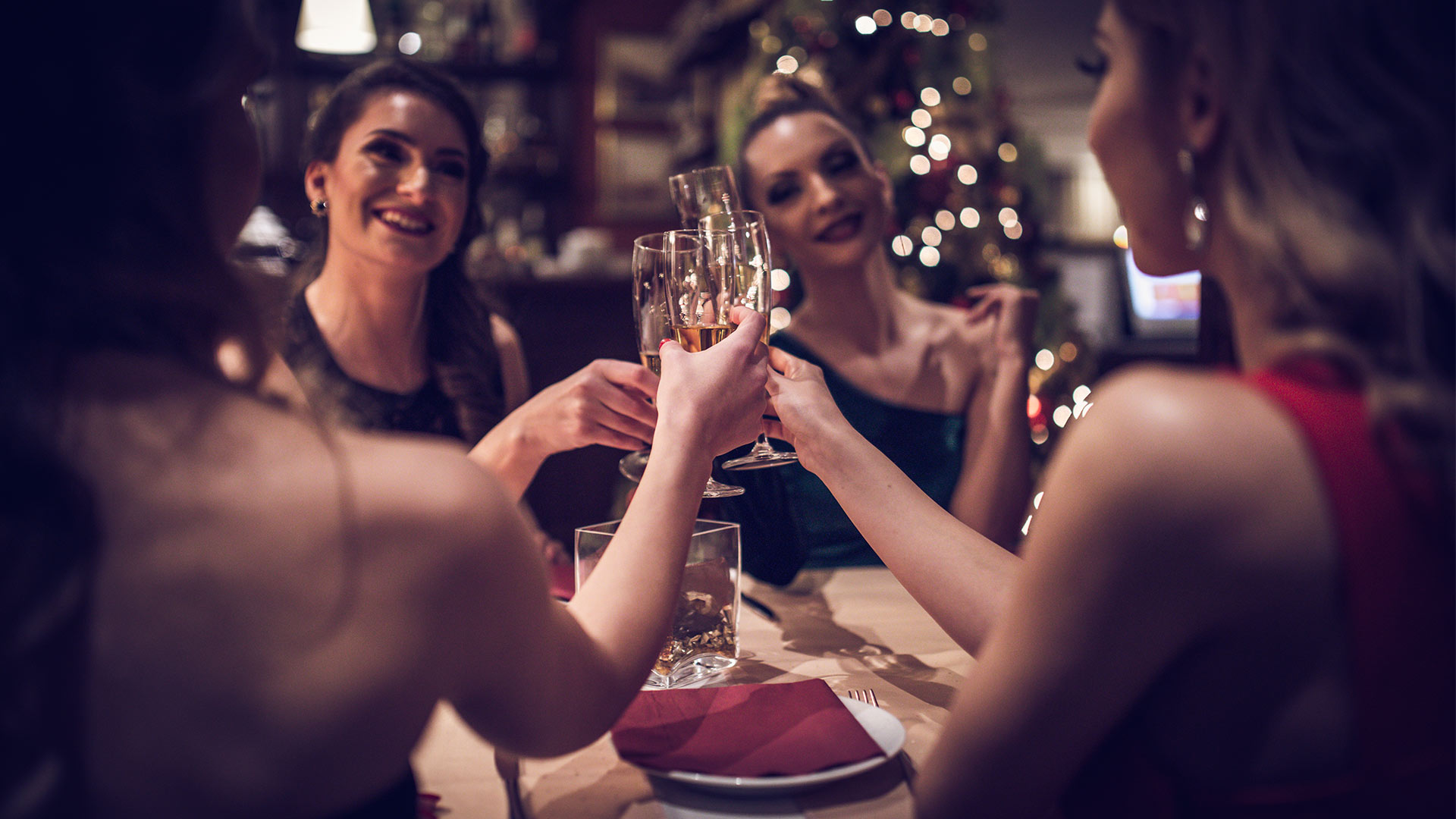 Group of women sitting at table having champagne