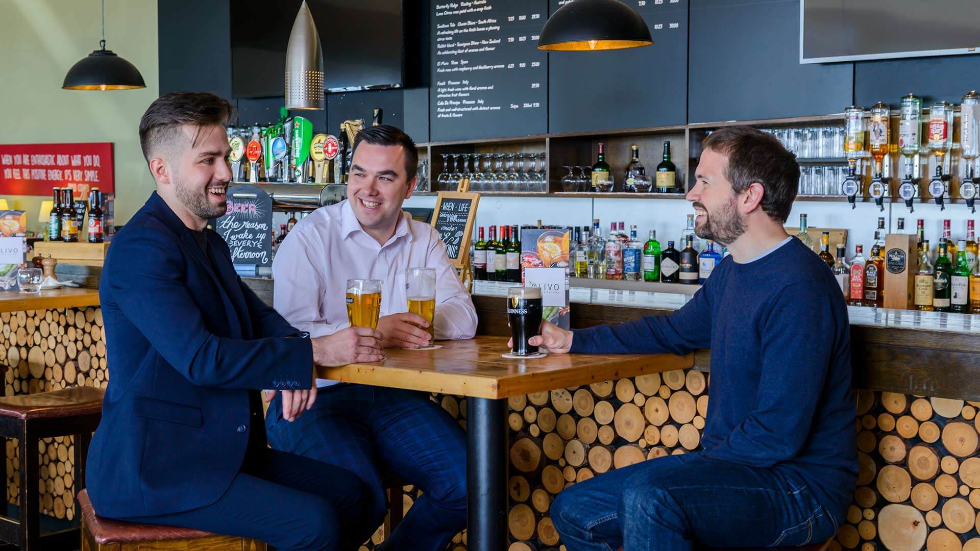 Three people enjoying drinks at the Olivo Restaurant and Bar at Cork Airport Hotel