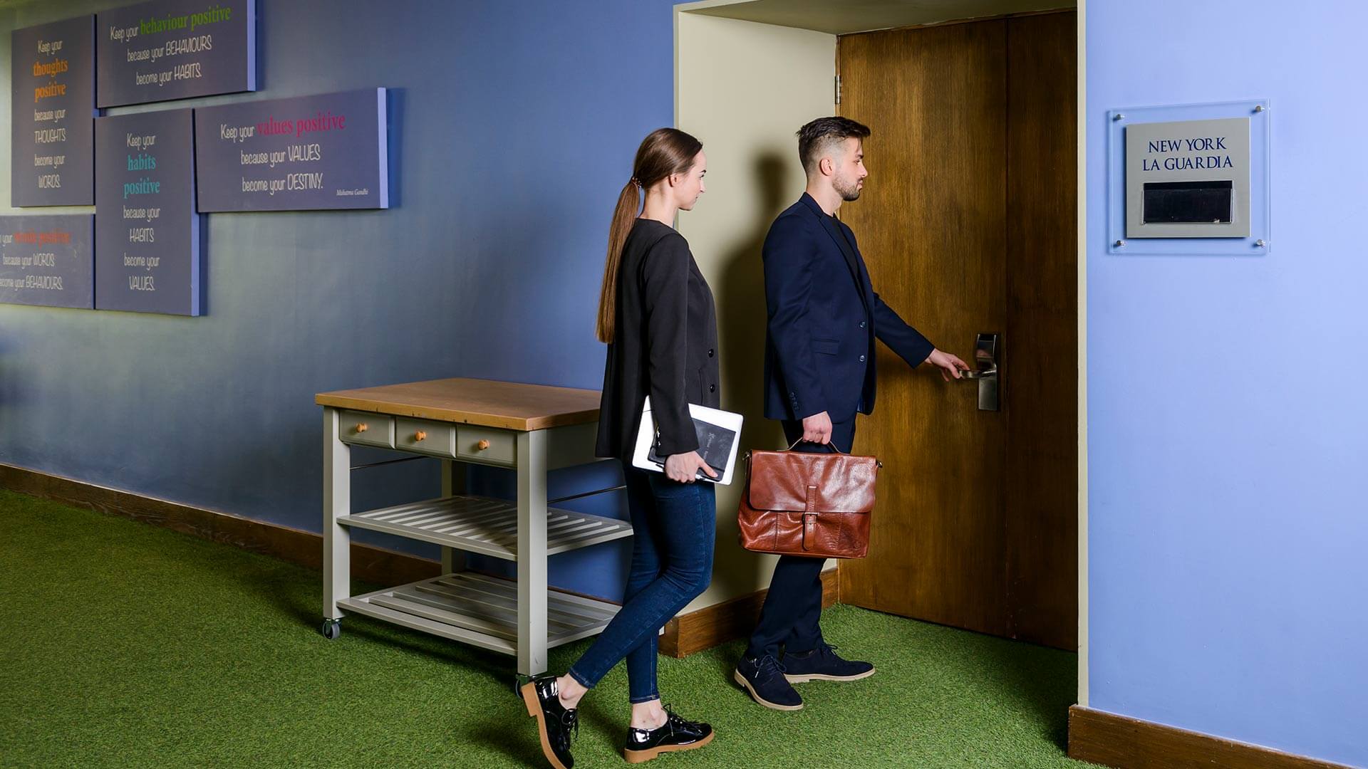 man and woman entering a meeting room