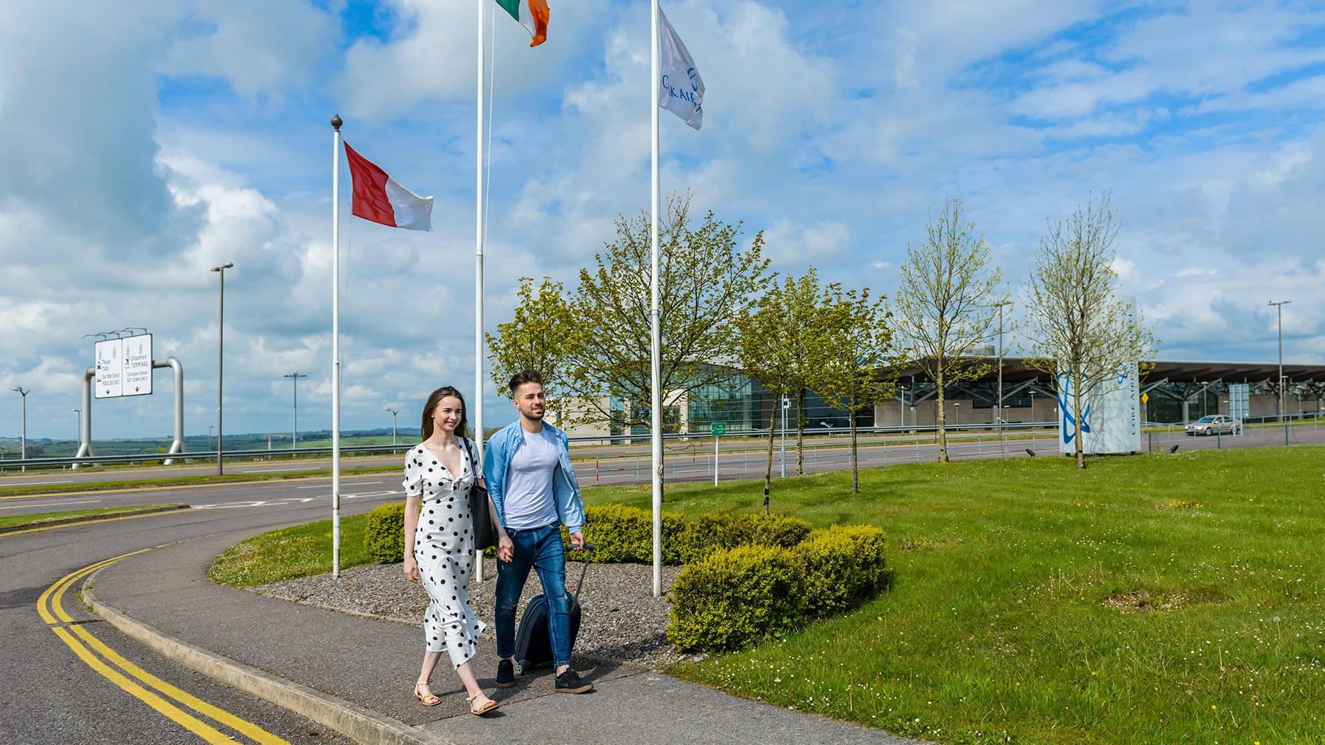 couple with suitcase wheelie bag walking outside Cork Airport Hotel