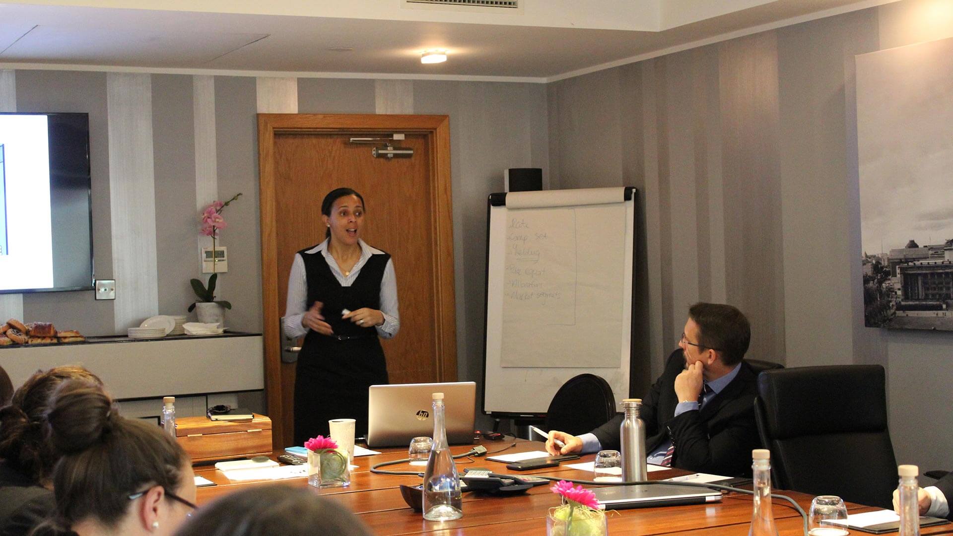 Business meeting with one person speaking to a table of delegates